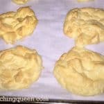 A baking sheet with several cloud bread doughnuts on it.