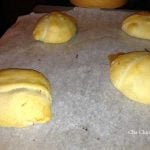 A baking sheet with a bunch of crescent rolls on it.