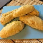 Five golden-brown, gluten-free breadsticks rest on a blue plate atop a bamboo mat, with "chachingqueen.com" printed at the bottom of the image.