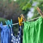 Clothes hanging on a clothesline in a garden, ready for removing stains.