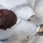 How To Make The Best Chocolate Mug Cake; White Mug Filled With Chocolate Cake